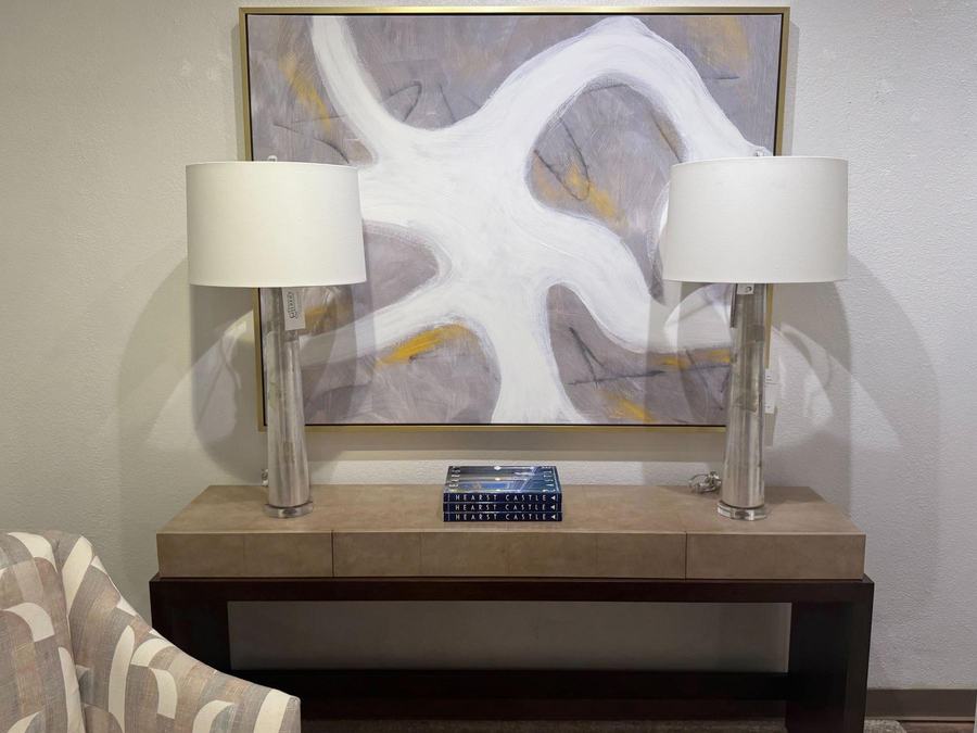 Console table with crystal lamps under an abstract painting